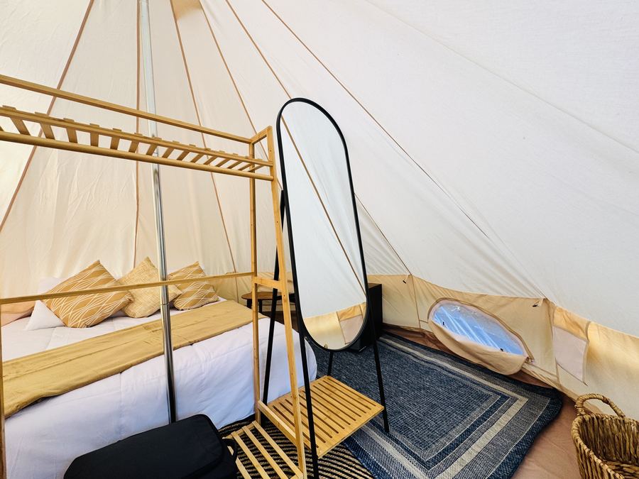 Interior de la carpa con cama y espejo